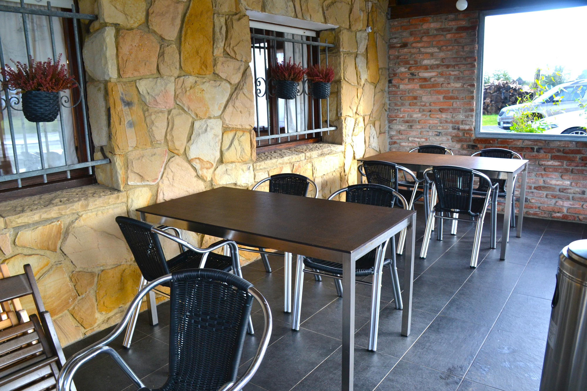 Mesas en la terraza exterior, acristalada en invierno y abierta cuando llega el buen tiempo.