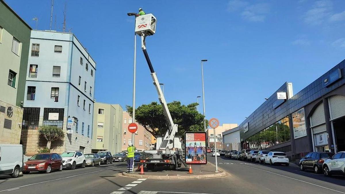 Un operario realiza trabajos en una farola.
