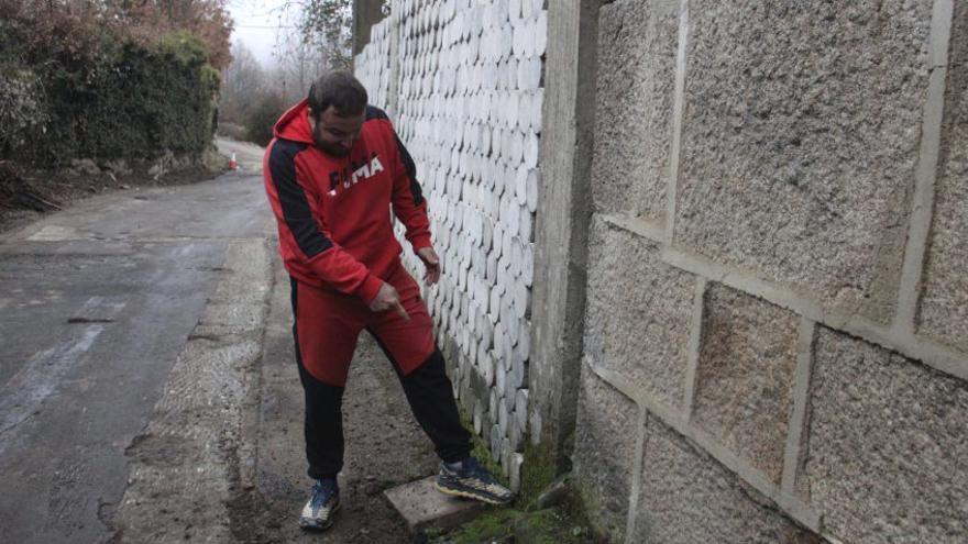 Un vecino señala una vivienda junto a la carretera que podría inundarse. | A. SAAVEDRA