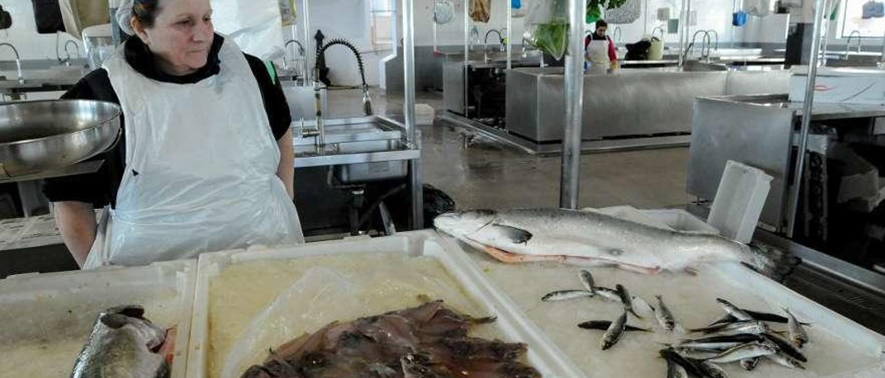 Arriba, una de las pocas pescantinas que ayer estaban en el mercado de Vilagarcía. A la derecha, la zona peatonal llena de coches aparcados. // Iñaki Abella