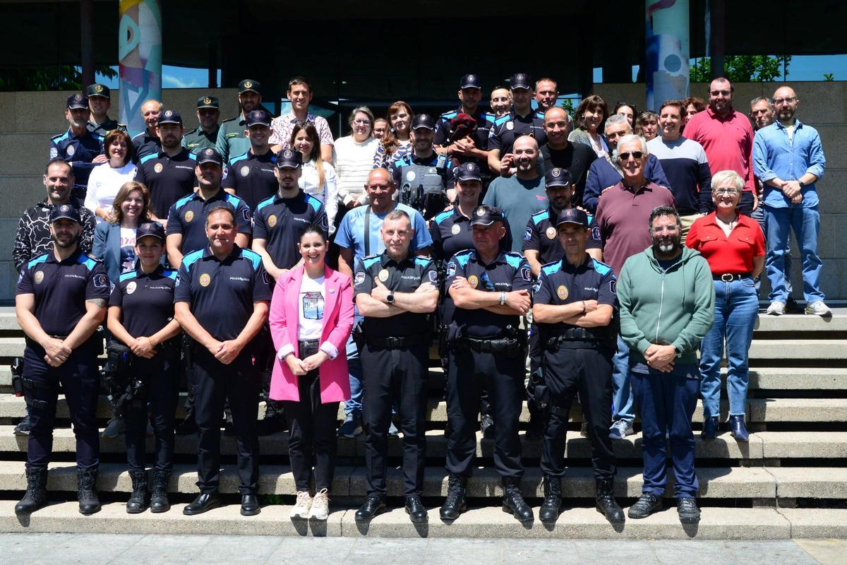 Foto de familia del homenajeado con miembros del gobierno, policías, trabajadores y Guardia Civil en el Concello.