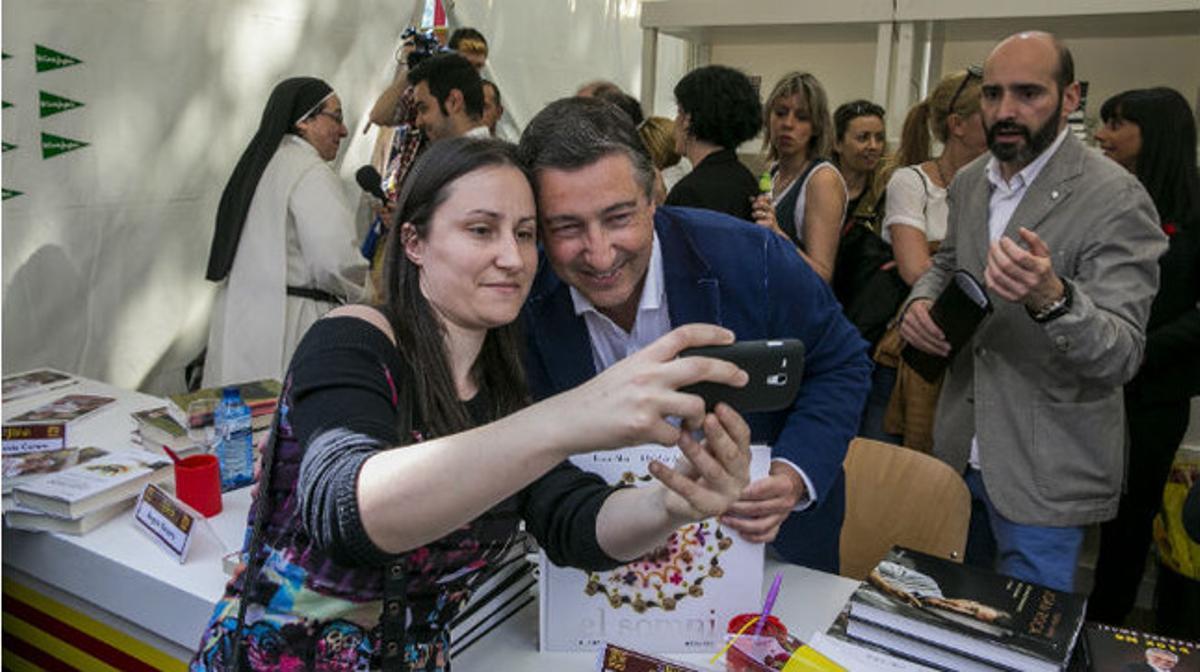 Una mujer se fotografía con el ’chef’ Joan Roca, que firma libros en Barcelona con motivo de la ’diada’ de Sant Jordi.