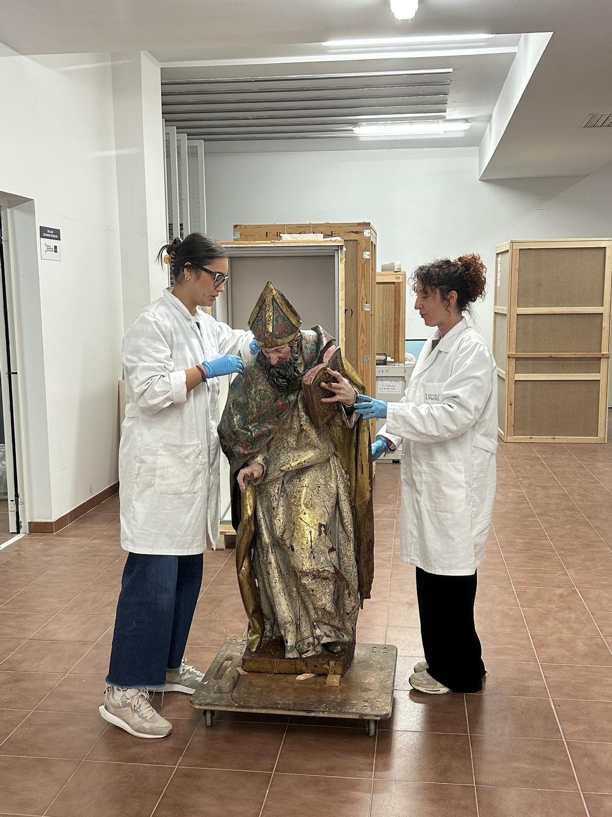 Varias restaudoras con una de las obras a su llegada al centro de restauración.