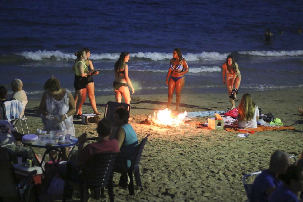 Noche de hogueras, baños, en las playas de la Vega Baja. En las imágenes grupos de amigos y familias en la playa del Cura de Torrevieja