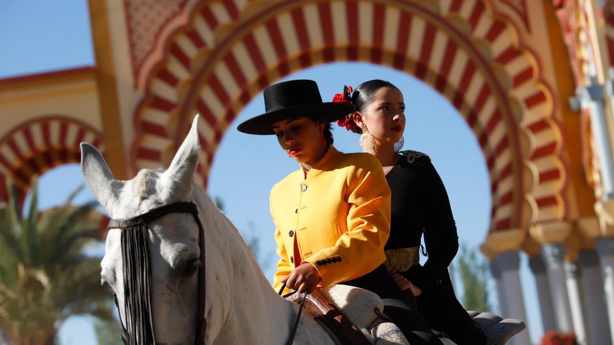 Foto de archivo de una jinete y una mujer vestida de gitana.
