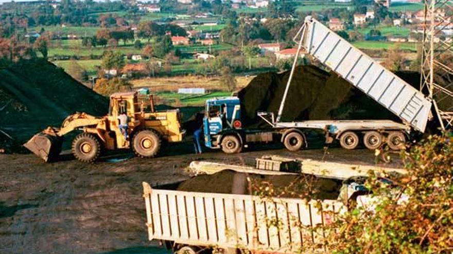 Un camión procedente del puerto de Avilés descarga carbón en Mina La Camocha, en diciembre de 1999, mientras otro aguarda su turno. Los finos de hulla llegaron al puerto avilesino en el barco &quot;Husnes&quot;.