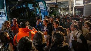 Varios pasajeros afectados por la huelga y el mal tiempo, ayer frente a los autobuses en el aeropuerto de El Prat