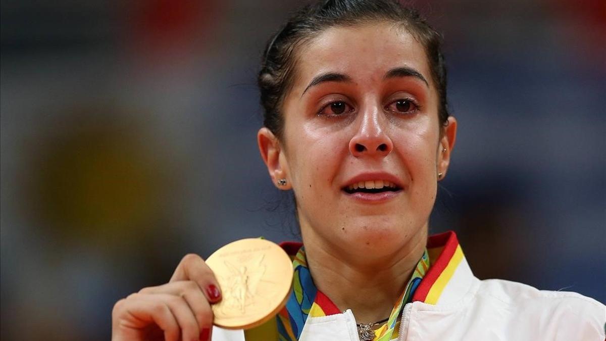 Carolina Marín llora en el podio con el oro olímpico colgado.