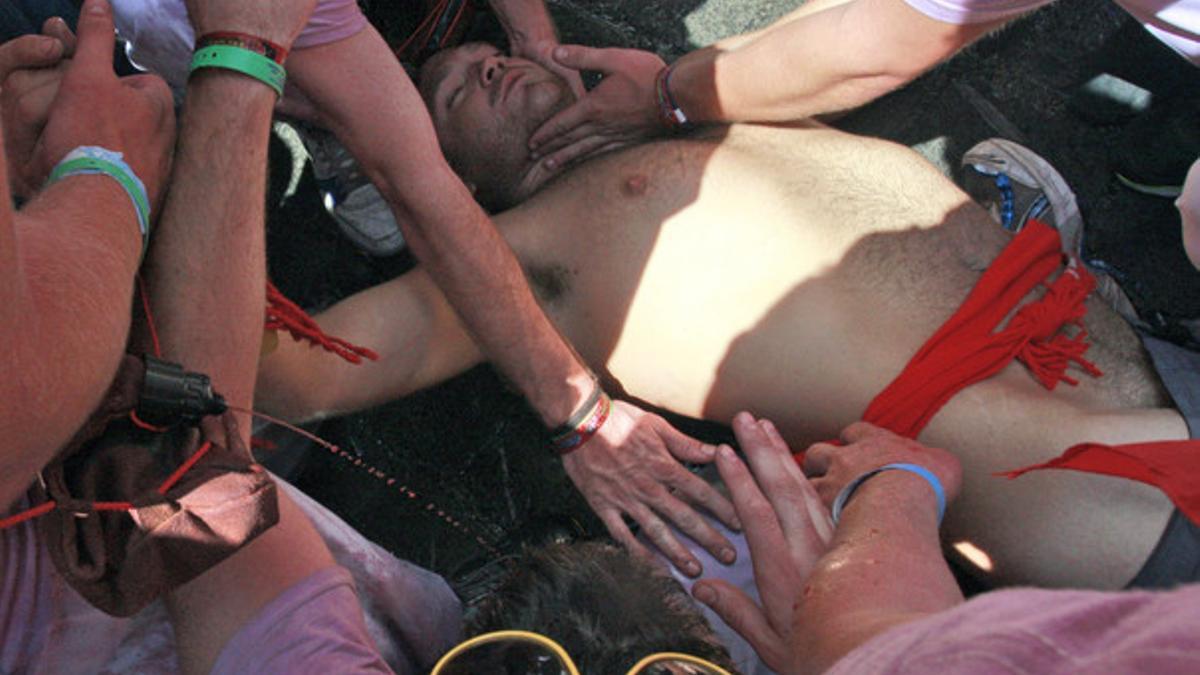 Un joven es atendido por un médico después de perder el conocimiento tras lanzarse desde la fuente de Navarrería
