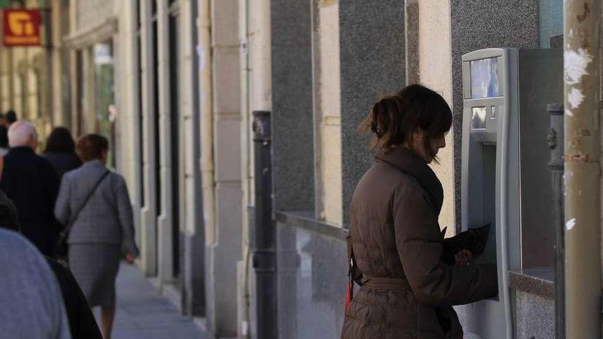 Una mujer saca dinero de un cajero automático.