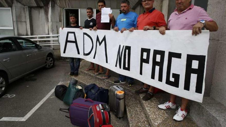 Los seis trabajadores de ADM muestran una pancarta en la puerta del Ayuntamiento.