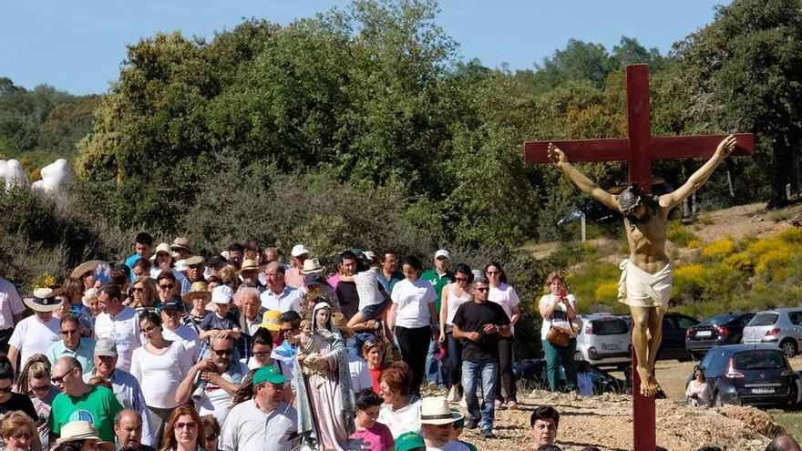 Un momento de la procesión con la Santa Cruz y la imagen de la Virgen llevadas a hombros.