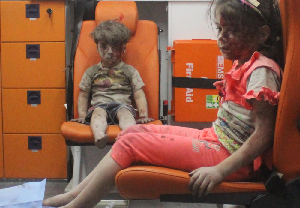 El niño Omran Daqneesh, de cinco años, y su hermana, esperan atención médica en una ambulancia después de ser rescatados de un ataque aéreo en  Alepo.