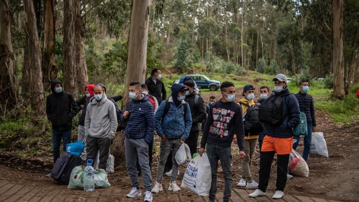 Inmigrantes en la entrada del campamento de Las Raíces.