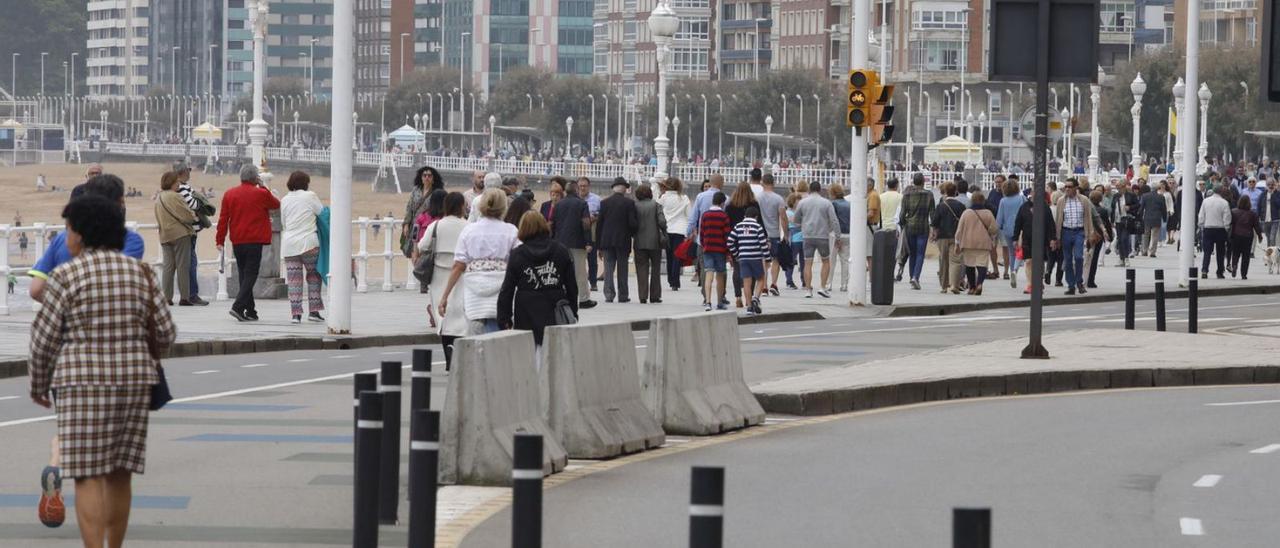 Viandantes por distintas zonas de paseo del Muro, con el “cascayu” a la izquierda. | Ángel González