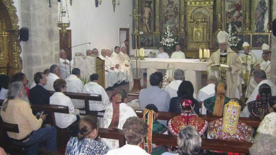 El obispo de Zamora, de pie, se dirige a los feligreses congregados en la iglesia durante la homilía.