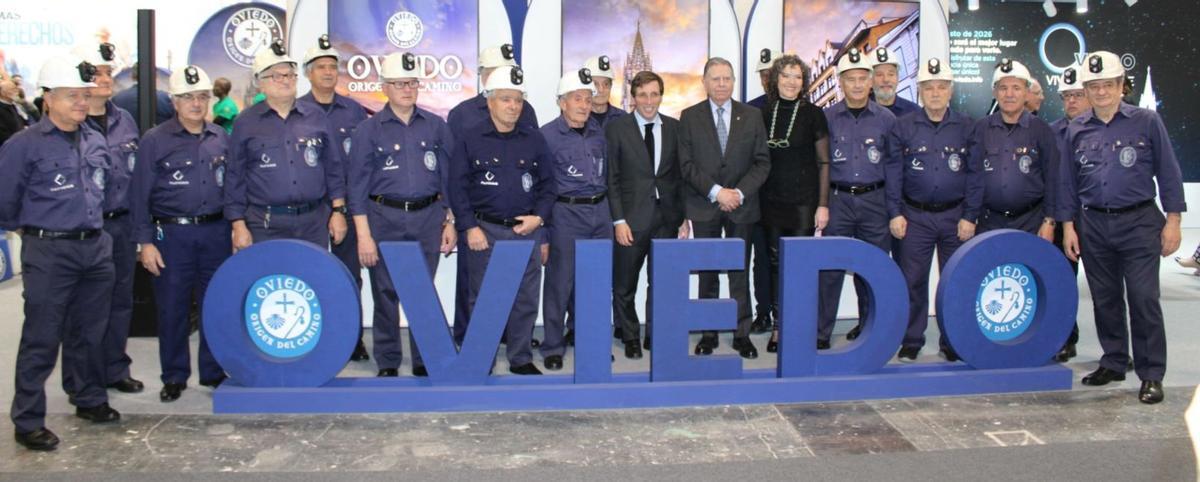 José Luis Martínez-Almeida y Alfredo Canteli posan junto al Coro Minero de Turón en el stand de Oviedo en Fitur.  | LNE