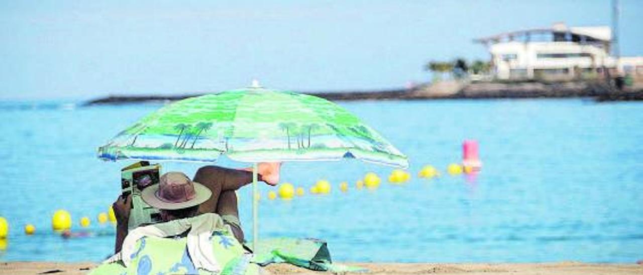 Un turista disfruta de una playa isleña. | | ANDRÉS GUTIÉRREZ