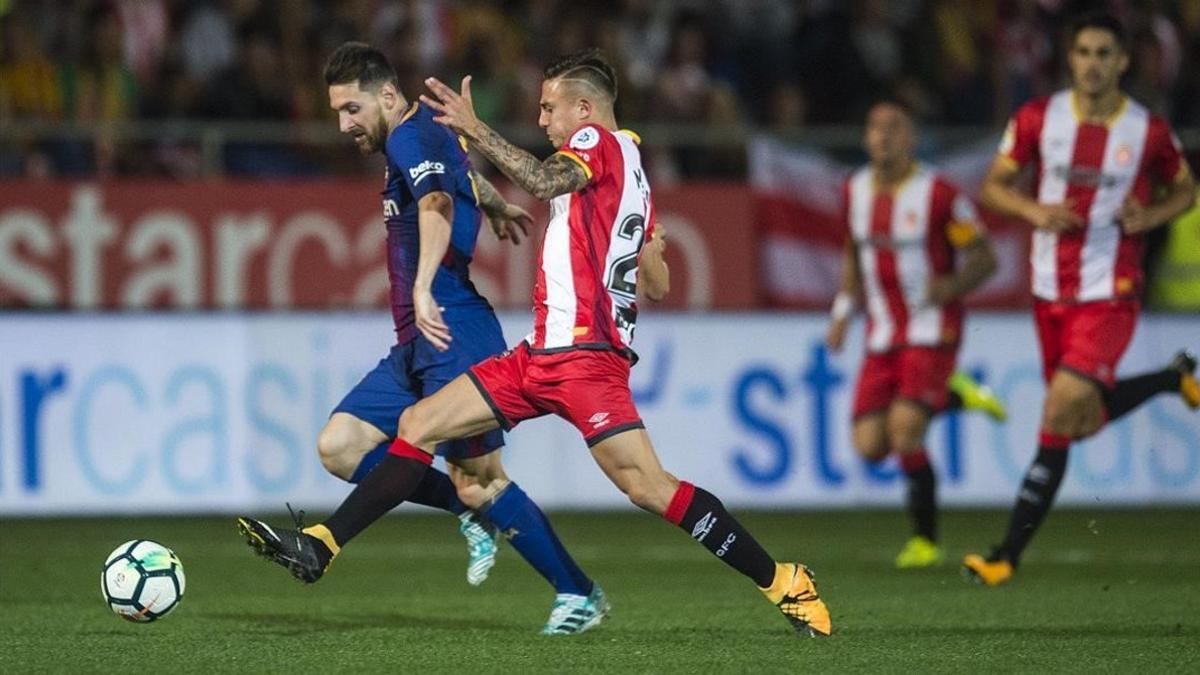 Messi trata de superar a Maffeo durante el partido de Montilivi.