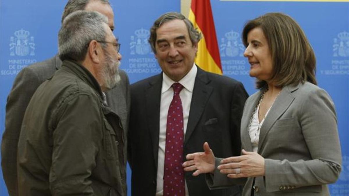 Báñez conversa con el líder de UGT, Cándido Méndez (izquierda) y el presidente de la patronal CEOE, Juan Rosell, el pasado abril.