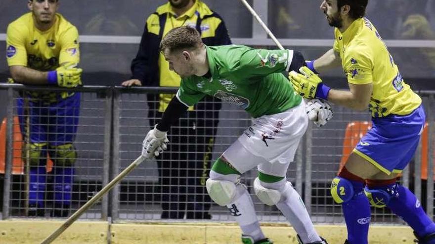 César Carballeira protege la bola ante un jugador asturiano.