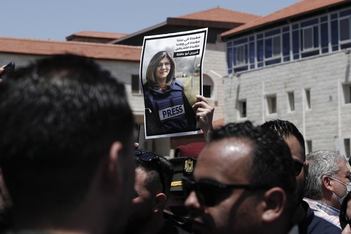 Un compañero porta la fotografía de la periodista palestina fallecida, en su entierro en Ramala.