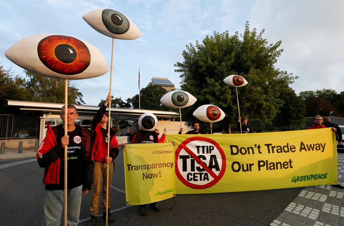 Greenpeace activists hold banners and giant eyes during a demonstration against the trade agreements TTIP, CETA and TiSA in front of the U.S. Mission in Geneva, Switzerland, September 20, 2016. REUTERS/Denis Balibouse