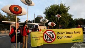 Greenpeace activists hold banners and giant eyes during a demonstration against the trade agreements TTIP, CETA and TiSA in front of the U.S. Mission in Geneva, Switzerland, September 20, 2016. REUTERS/Denis Balibouse