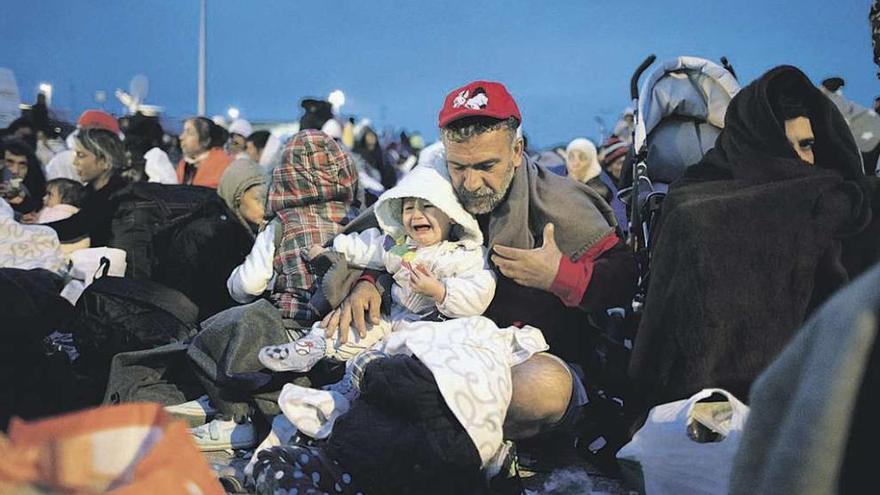 Refugiados esperan por un transporte, tras llegar a la frontera austriaca en autobús desde Hungría. // Reuters