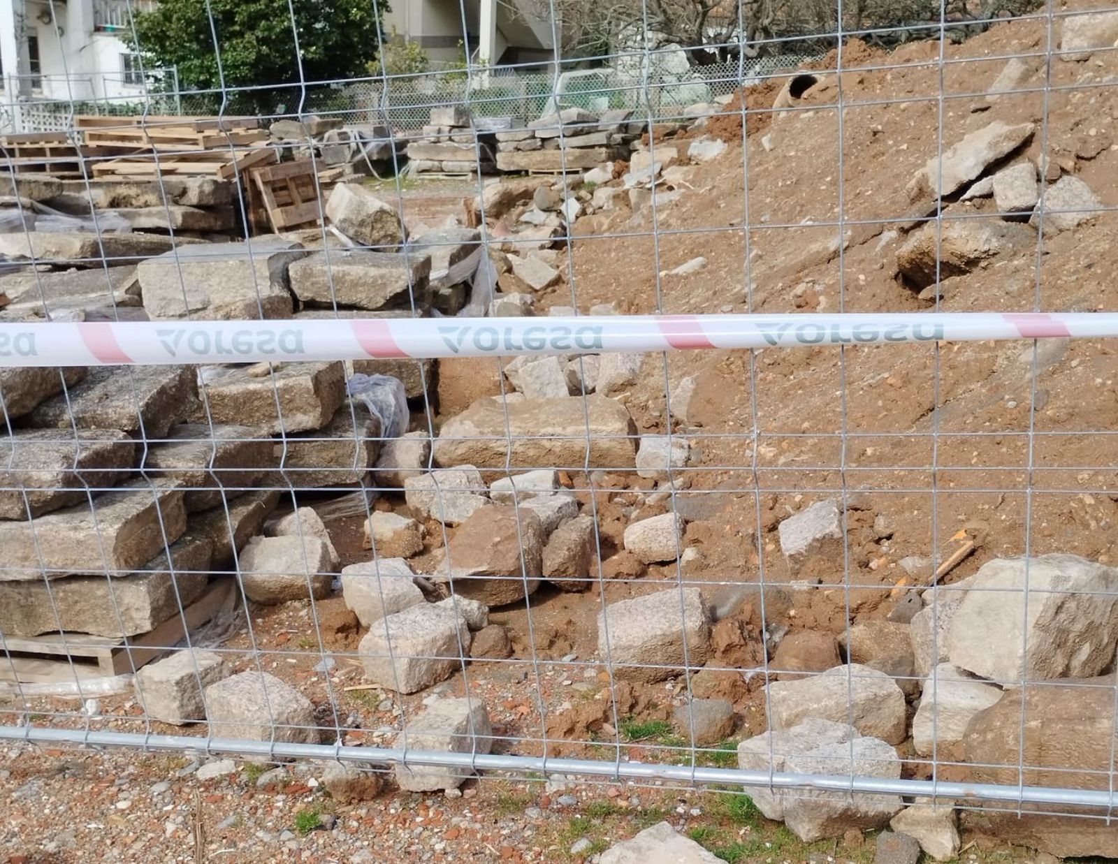 Piedras y restos de adoquines de la rúa da Estrela, almacenados en el parking de Altamira.