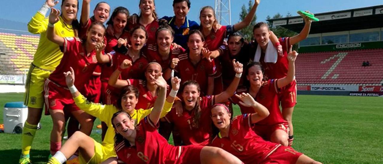 Cata Coll, sentada en el suelo de color amarillo, celebra el título con España sub-17.