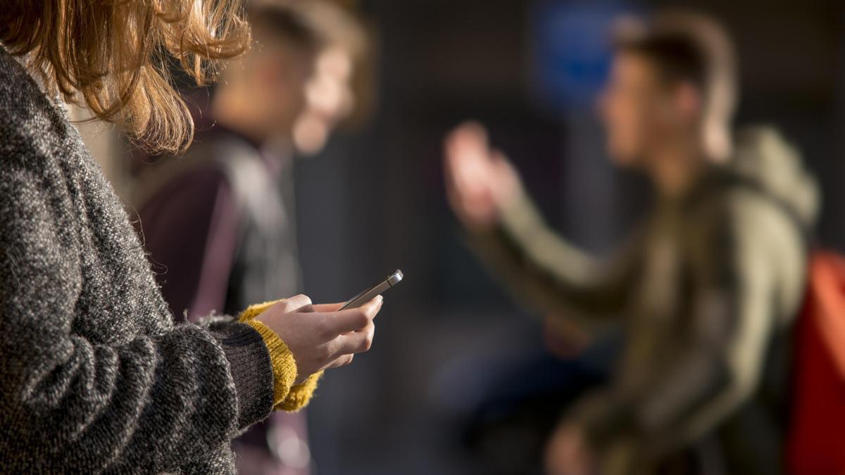 Una niña consulta internet a través de su móvil.