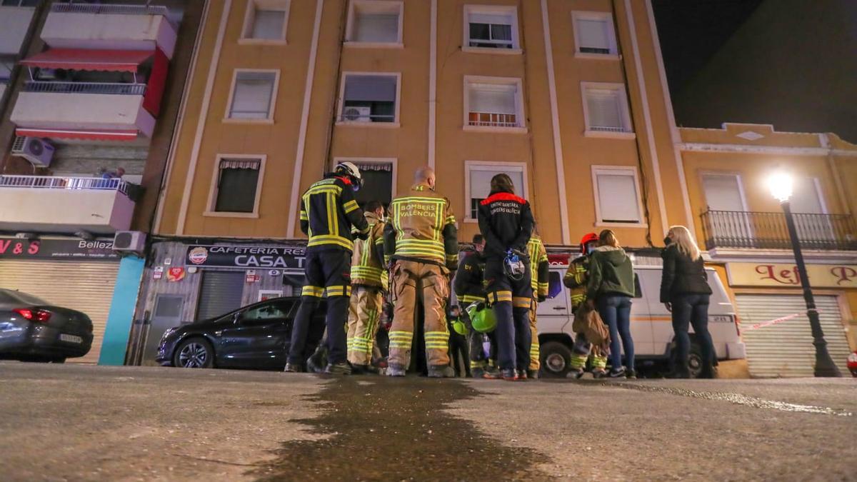 Bomberos y servicios de emergencia frente al portal donde ha ocurrido el incendio en la Malva-rosa.