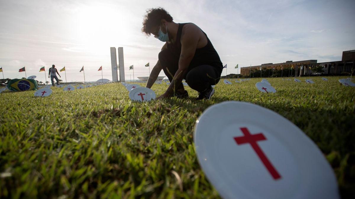 Integrantes de la ONG Rio da Paz colocan platos con cruces rojas frente al edificio del Congreso Nacional en Brasilia.