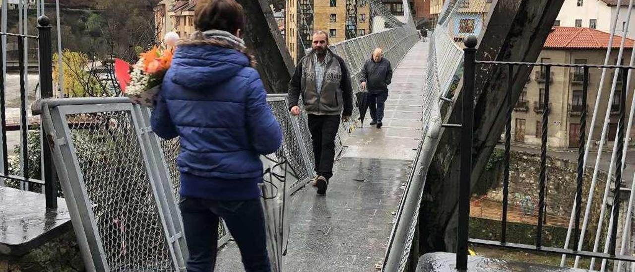 Vecinos cruzando el puente colgante de Cangas del Narcea.