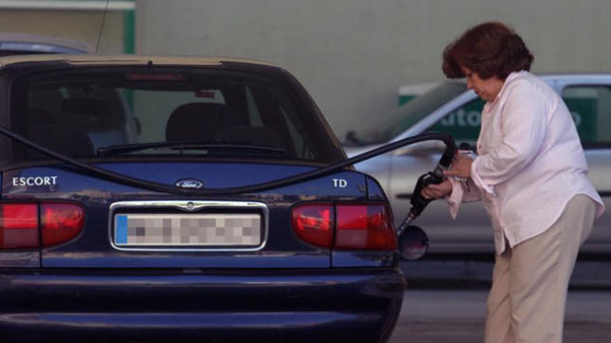 Una conductora echa gasolina en una estación de la capital.