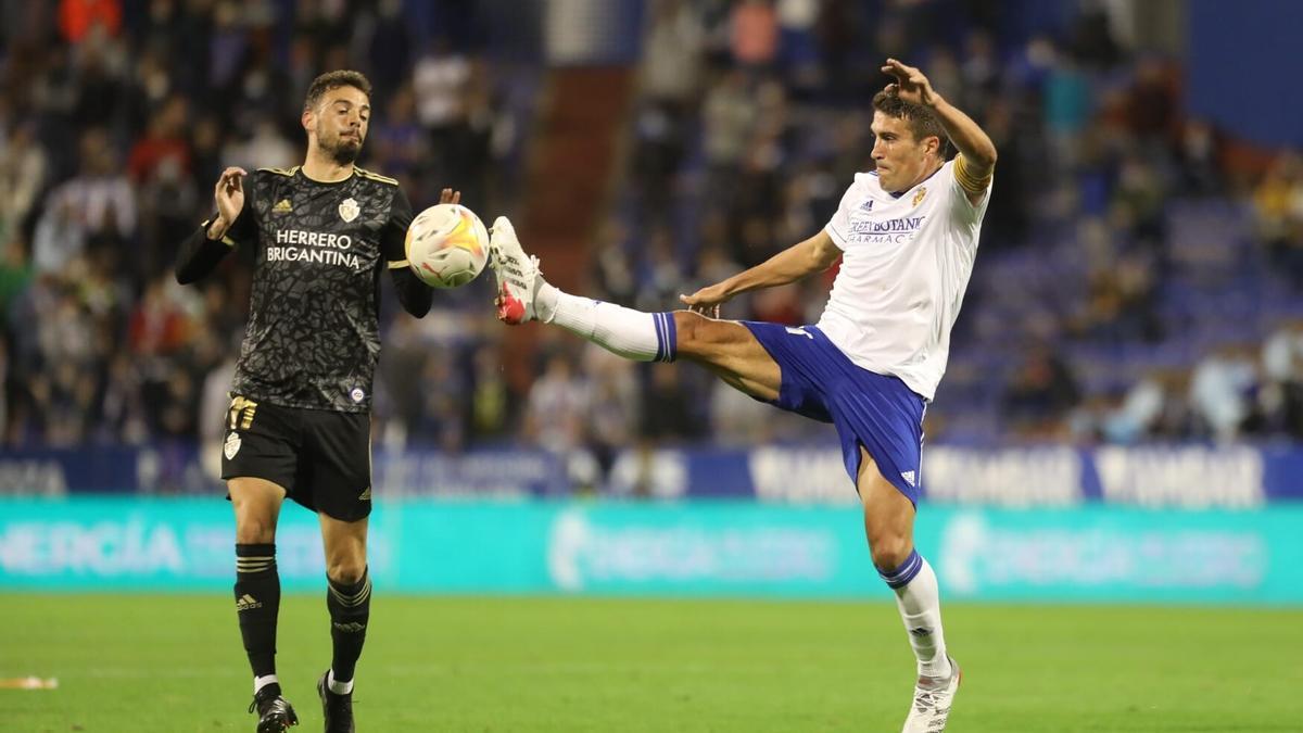 Zapater intenta anticiparse a Cristian en la disputa de un balón durante el partido.