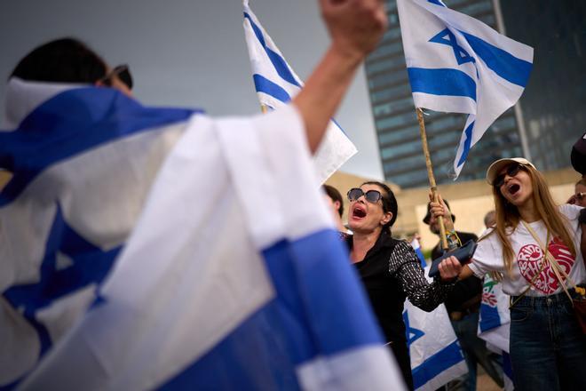 People react as they celebrate following the announcement that Israel and Hamas have agreed to the first phase of a peace plan to pause the fighting, at a plaza known as hostages square in Tel Aviv, Israel, Thursday, Oct. 9, 2025. (AP Photo/Emilio Morenatti). EDITORIAL USE ONLY/ONLY ITALY AND SPAIN
