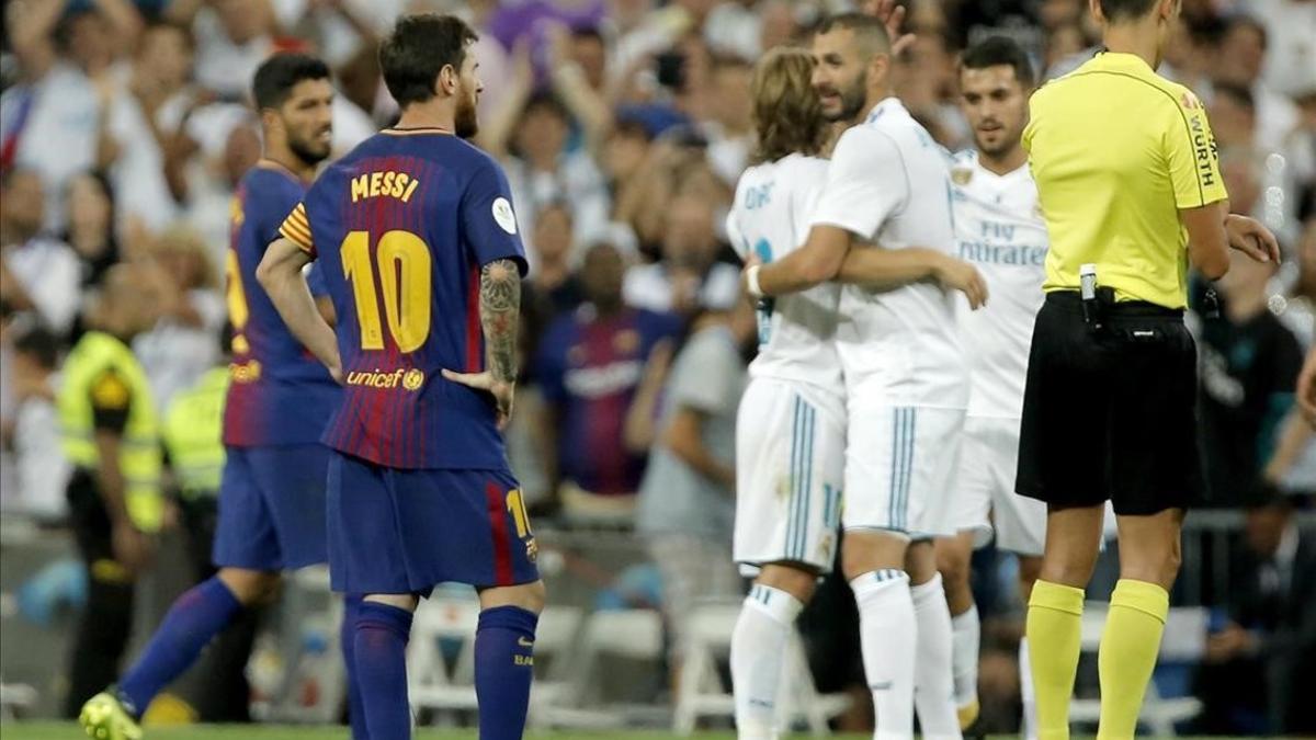 Benzema es felicitado por su gol, con Messi como testigo