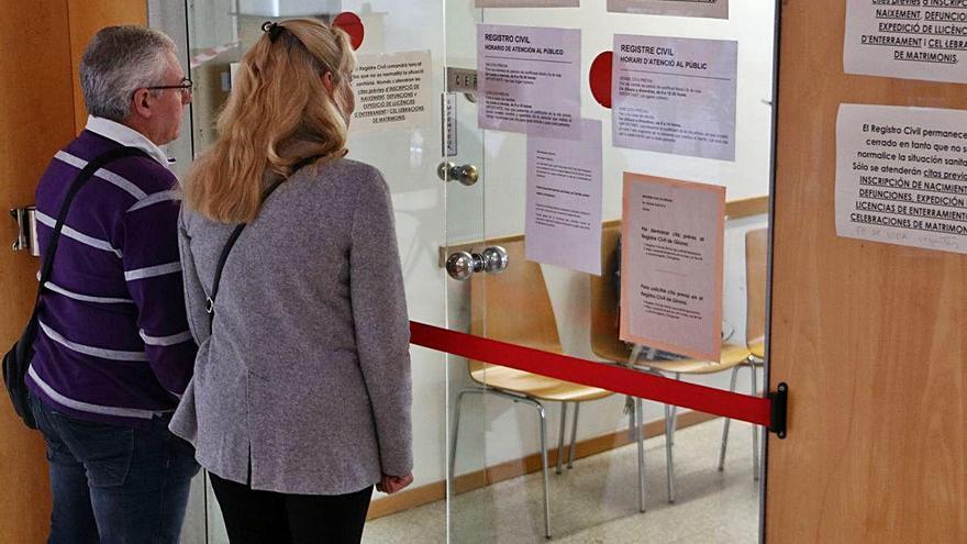 Una parella davant la porta del Registre Civil dels jutjats de Girona.