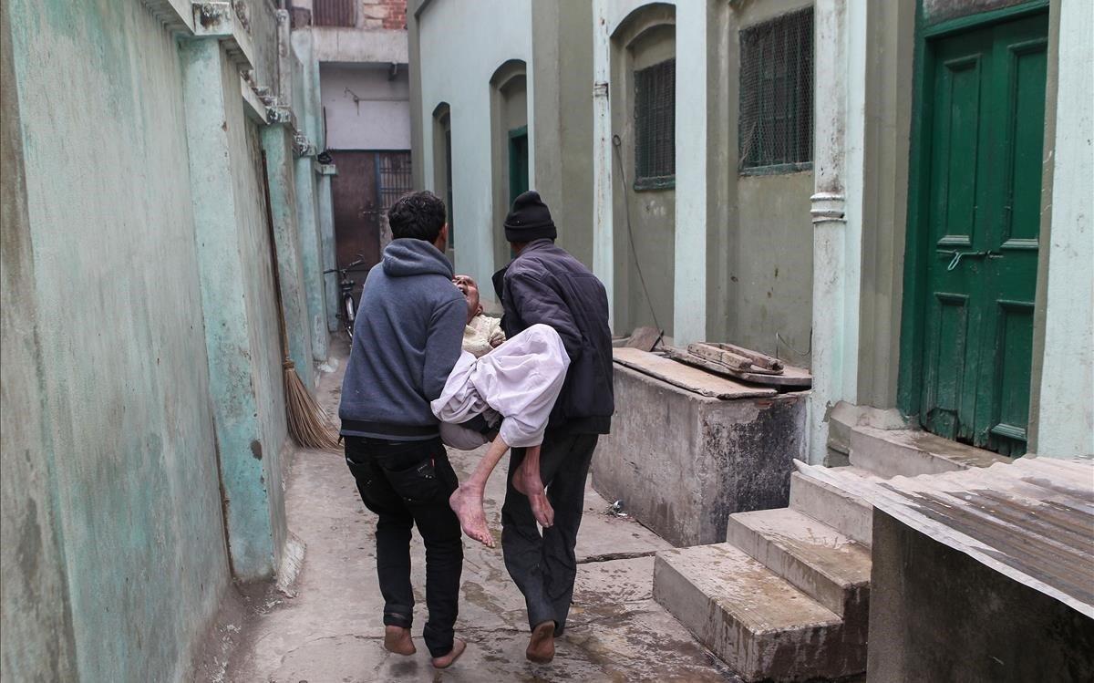 Familiares llevan a Halkey Singh Raghuvansi de 85 años, al Kashi Labh Mukti Bhawana o Salvation House, conocido como un hotel de la muerte para peregrinos moribundos en Varanasi. Cada mes, aproximadamente 20 hombres y mujeres vienen de todo el mundo para terminar sus días en la ciudad santa de Varanasi. El hotel es un viejo edificio rojo de la era colonial, con 12 habitaciones de pisos de hormigón.