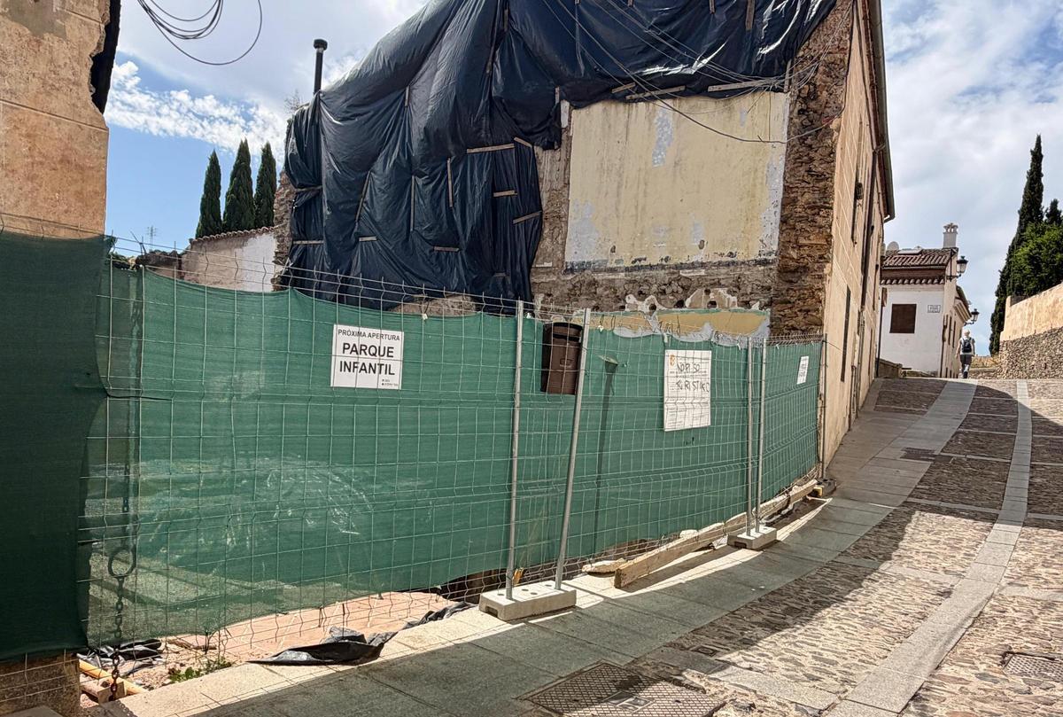 El cerramiento de la obra, con el falso anuncio de un parque infantil y las pintadas contra los apartamentos turísticos.