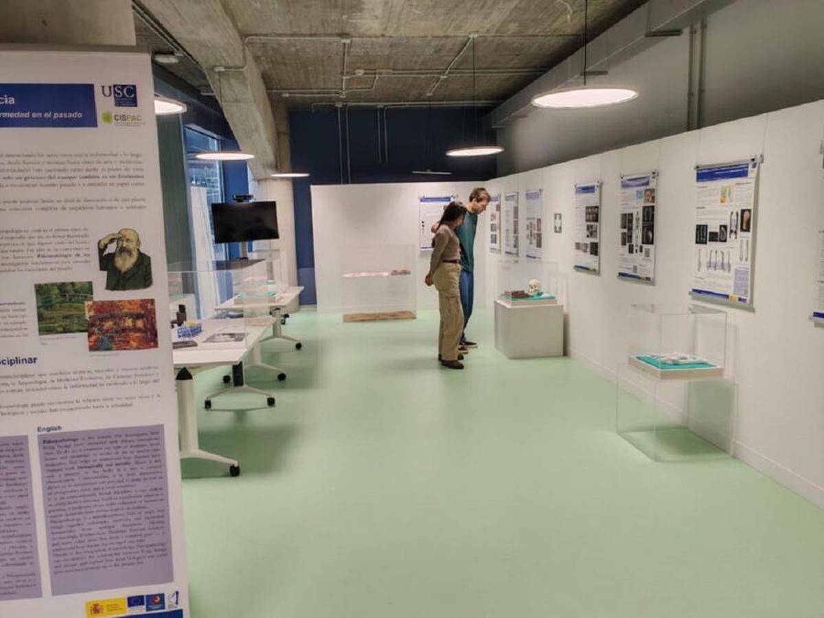 Dos personas en el montaje de la exposición de la USC que se inaugura este lunes en Santiago.