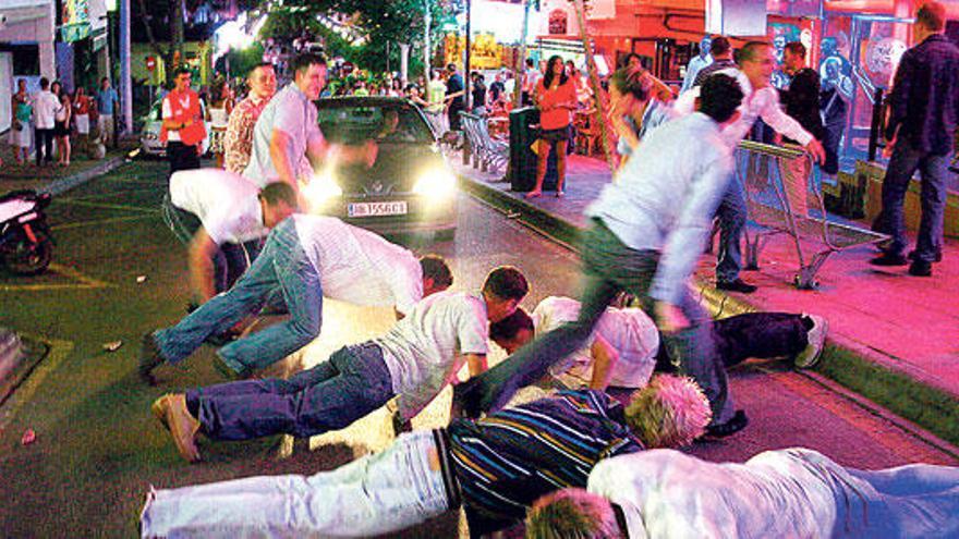 Un grupo de turistas hace flexiones en medio de la vía pública, en Magaluf.