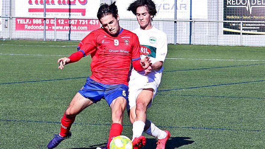 Manu, del Choco, defiende el balón ante la presión de un rival. |  // FDV