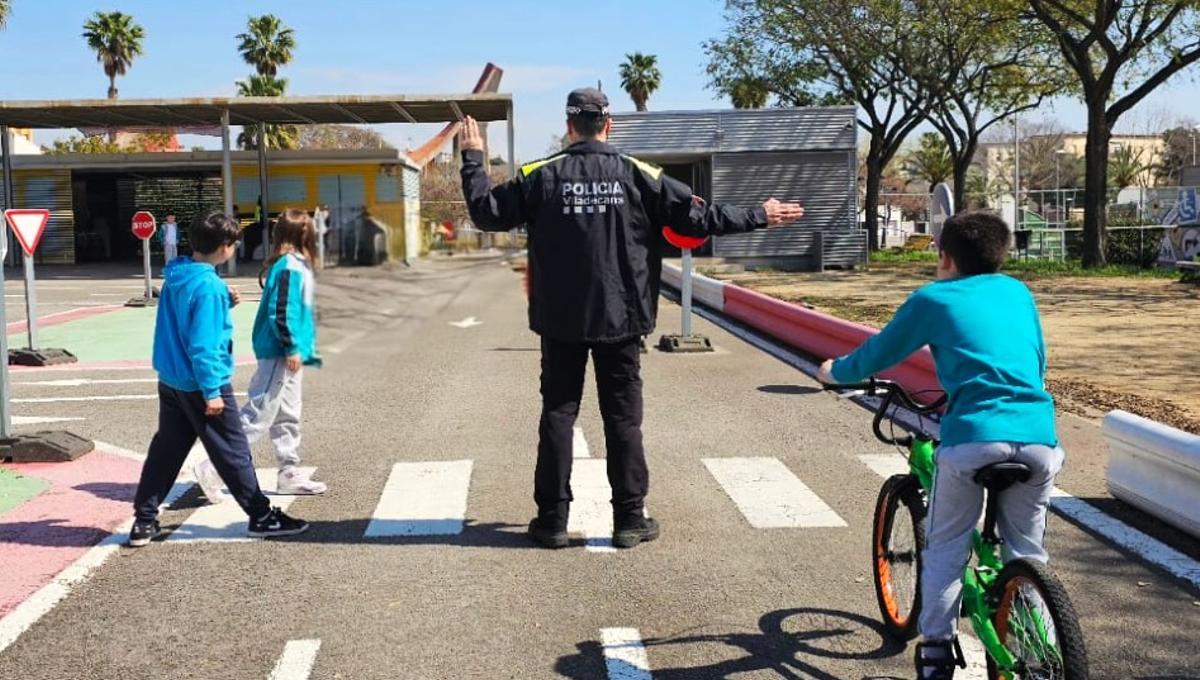 Un agente de la policía de Viladecans instruye a niños en el Parque Infantil del Tráfico (PIT) de la ciudad.