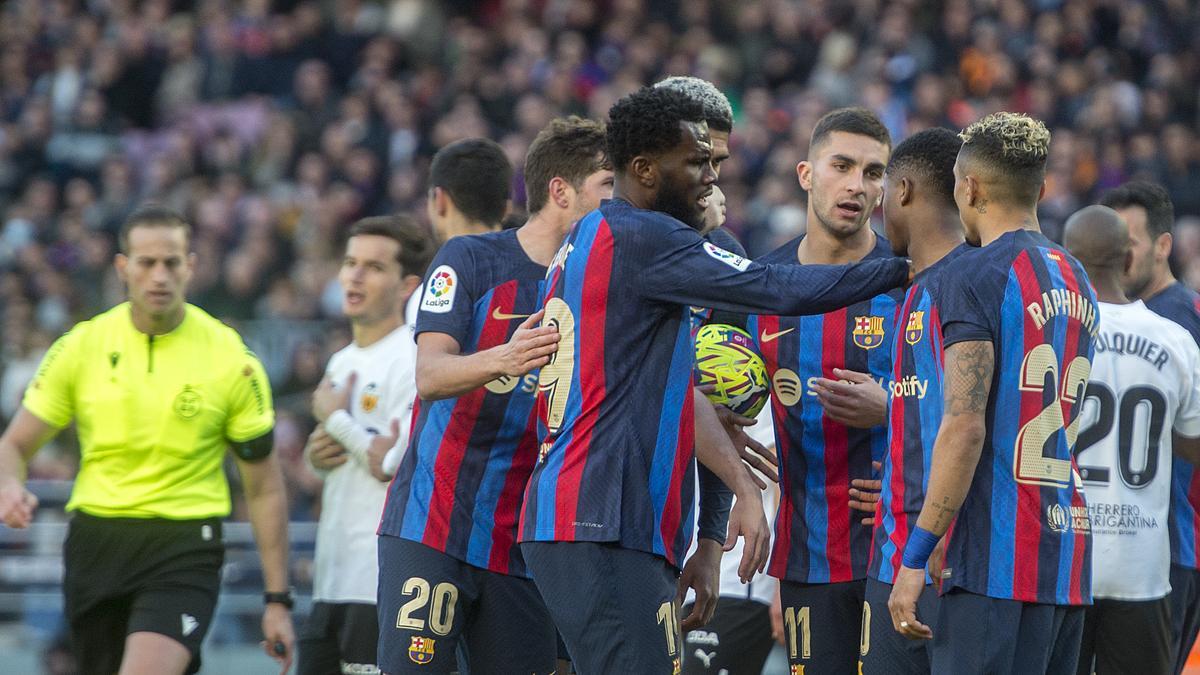 Los jugadores azulgrana, Ferran Torres con el balón bajo el brazo, debaten sobre quién tira desde el punto de penalti durante el partido de liga contra el Valencia