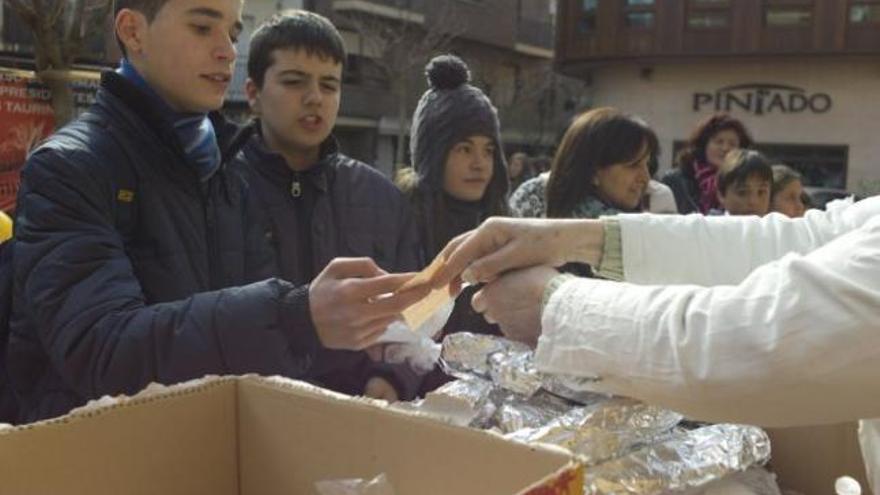 Un grupo de jóvenes intercambia el tícket de 2,50 euros por el bocadillo en la plaza de Santa María.