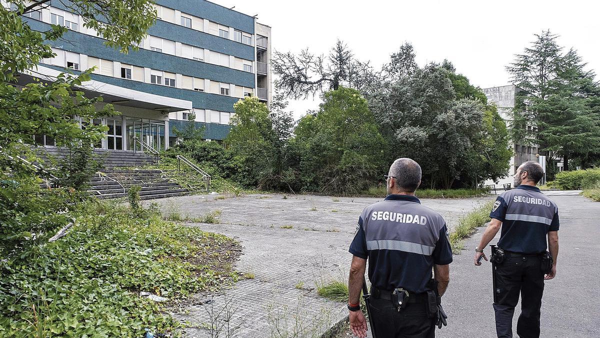 Dos guardias de seguridad, patrullando por el viejo HUCA en la tarde de ayer.