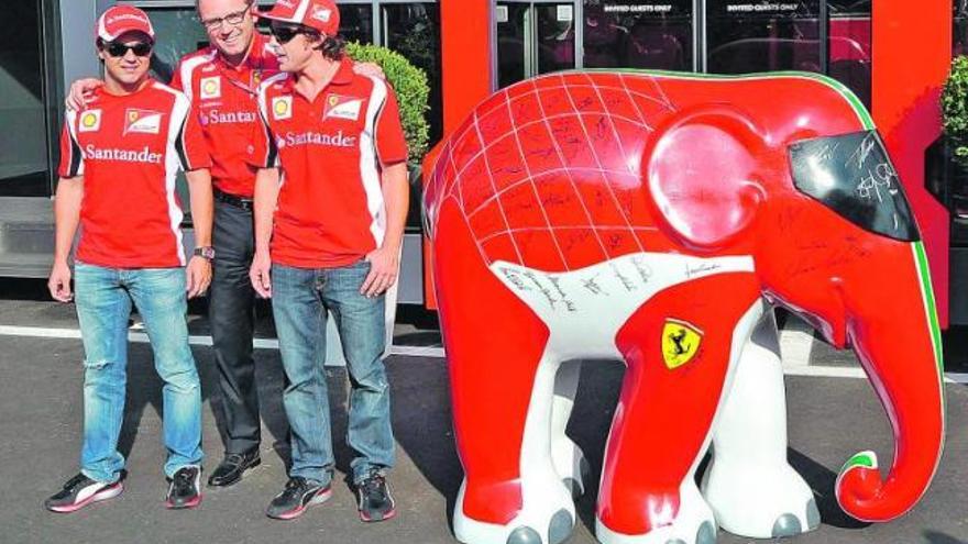 Felipe Massa, Stefano Domenicali y Fernando Alonso posan ante el motorhome de Ferrari con «Nello», la nueva mascota de la escudería italiana.